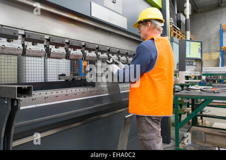 Industria del metallo lavoratore controlli angolo sulla lamiera piegata, la parte. Foto Stock