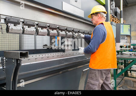 Industria del metallo lavoratore controlla una lamiera piegata parte Foto Stock