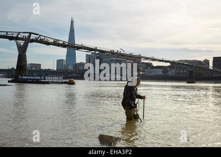 Londra, Regno Unito. 10 marzo, 2015. Una molla bassa marea lungo il fiume Tamigi e un 'Mudlark' ricerca storica monete perse e artefatti Credito: Steve Hickey/Alamy Live News Foto Stock