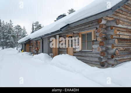 Un log cabin nella neve in inverno. Affitto di vacanze nella località sciistica di Levi, Lapponia, Finand Foto Stock