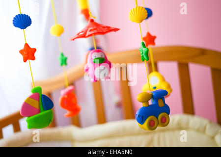 Giocattoli per i bambini appeso dal presepe Foto Stock