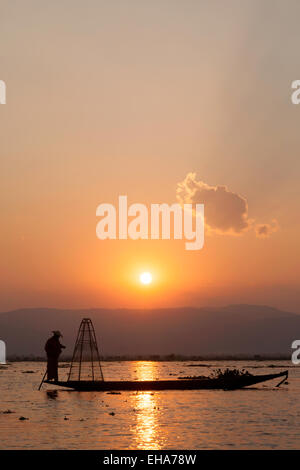 Un pescatore di pesca con la sua forma a cono net al tramonto, Lago Inle, Myanmar ( Birmania ), Asia Foto Stock