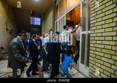 Gli ebrei entrano nella sala da preghiera e di Yusef Abad sinagoga, uno dei più grandi nel nord di Teheran e toccando mezuzà, rituale pezzo di pergamena, su Rosh Hashanah, ebraica Anno nuovo, Iran Foto Stock