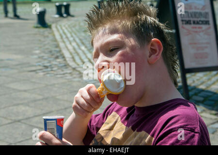 Ragazzo giovane mangiare e gelato in una calda giornata estiva in Bristol Foto Stock