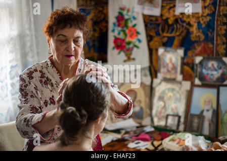 Milinchuk Halina, medicina alternativa praticante, guarire il suo paziente, il rotolamento delle uova sul suo corpo e ortografia Duo-teistica Pagan-Christian preghiera, Koziatyn, regione Vinnytsia, Ucraina Foto Stock