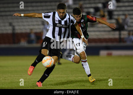 Montevideo, Uruguay. Decimo Mar, 2015. Il Wanderers Nicolas Albarracin (L) dell'Uruguay il sistema VIES per la palla con Palestino's Esteban Carvajal del Cile durante il match di Copa Libertadores nel Gran Parque Central Stadium di Montevideo, capitale dell'Uruguay, 10 marzo 2015. © Nicolas Celaya/Xinhua/Alamy Live News Foto Stock