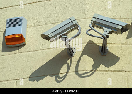 Le telecamere di sicurezza e sirena su una parete di un edificio Foto Stock