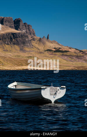 Il Storr e il vecchio uomo di Storr sotto un profondo cielo blu con un bianco di piccole barche a remi su Loch Fada in primo piano. Isola di Foto Stock