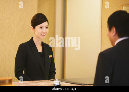 Femmina giapponese hotel concierge ha a che fare con un cliente Foto Stock