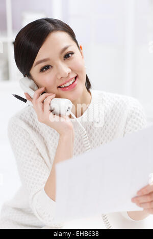 Oriental gioventù business donna consente di effettuare una chiamata telefonica Foto Stock