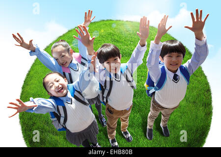 Gli alunni si fermò sulla terra a braccia alzate cheers Foto Stock