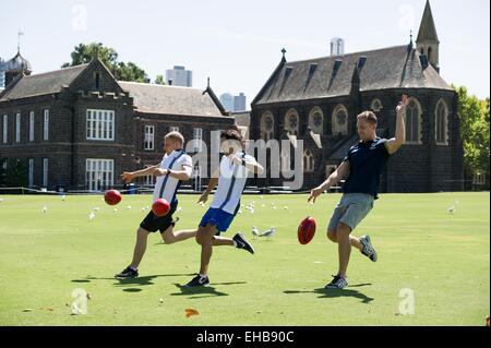 (150311) -- MELBOURNE, Marzo 11, 2015 (Xinhua) -- piloti di Formula Uno il finlandese Valtteri Bottas (L) e il brasiliano Felipe Massa(C) dal team Williams tenti Australian Rules Football con AFL player Joel Selwood durante la loro esperienza di AFL sessione alla scuola di grammatica de Melbourne a Melbourne, Australia sul Mar 11, 2015. (Xinhua/Bai Xue) Foto Stock