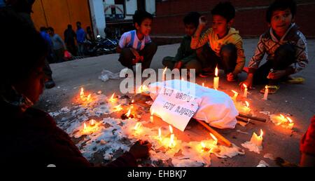 Kathmandu, Nepal. Undicesimo Mar, 2015. Popolo nepalese sedersi attorno al corpo di un bambino di sei anni ragazza che secondo come riferito è stata violentata nel suo villaggio a pochi giorni fa a Kathmandu, Nepal, Marzo 11, 2015. Credito: Xinhua/Alamy Live News Foto Stock