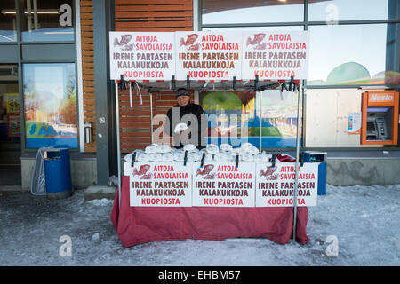 Un uomo vendere il kalakukko un finlandese tradizionale focaccia cotta al forno ripiene di pesce e di carne su una fase di stallo in Levi Lapponia Finlandia Foto Stock