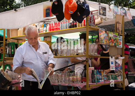 Argentina, Buenos Aires, San Telmo domenica street market, stallholder quotidiano di lettura Foto Stock