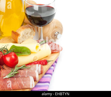 Vino rosso con formaggio, prosciutto, pane, spezie e verdure. Isolato su sfondo bianco con spazio di copia Foto Stock