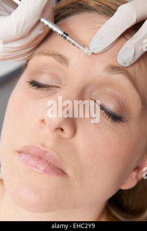 Donna con iniezione di Botox in fronte Foto Stock