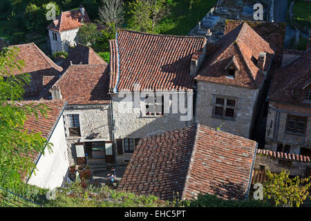 Guardando verso il basso su vecchi tetti rossi di belle case in pietra a St Cirq-Lapopie village Midi-pirenei, Lot, Cahors, Francia Foto Stock