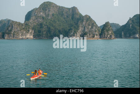 Canoa,canoisti, tra Carso montagne calcaree a Cat Ba National Park, Ha long,Halong Bay, Vietnam. Foto Stock