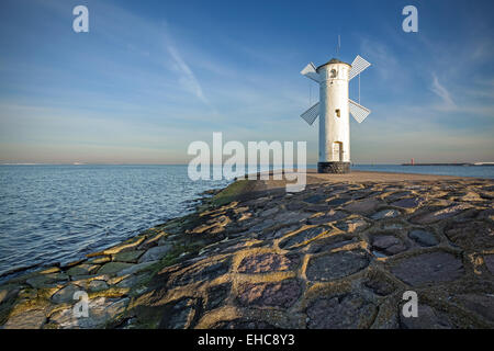 Alba sulla costa, il mulino a vento di faro a Swinoujscie, Polonia. Foto Stock