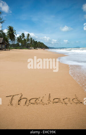 La parola Thailandia scritto nella sabbia al bordo dell'acqua, su una spiaggia in Thailandia. Foto Stock