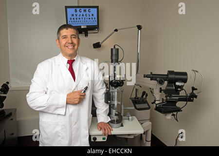 Occhio ispanica medico in sala esame circondato da test di macchine Foto Stock