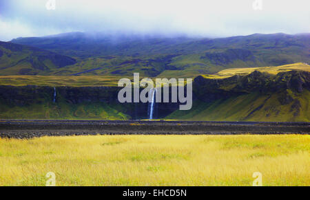 Sun e basse nubi sulla cascata Seljalandsfoss Foto Stock