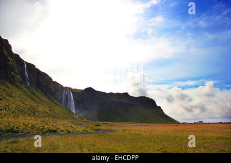 Sun e basse nubi sulla cascata Seljalandsfoss Foto Stock