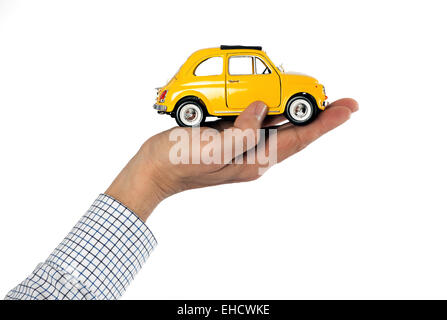 Maschi adulti con mano visibile Maglietta a strisce di ritegno manicotto giallo auto giocattolo contro uno sfondo bianco, Cura Auto immagine a tema Foto Stock