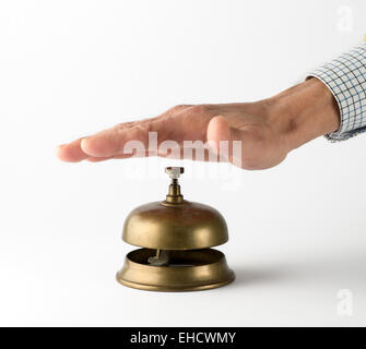 Imprenditore con mano visibile della Manica in ottone che squilla campana di servizio su sfondo bianco Foto Stock