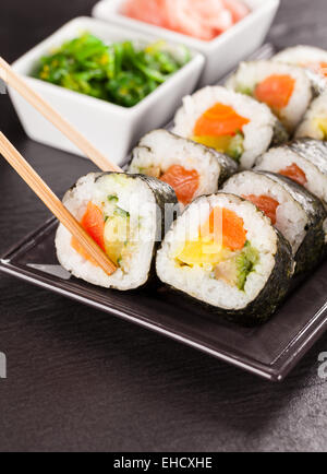 Delizioso sushi rotoli servita su piastra nera e pietra Foto Stock
