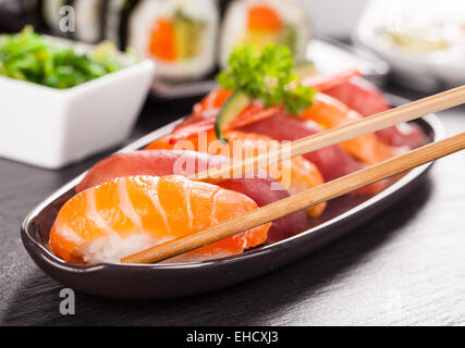 Delizioso sushi rotoli servita su piastra nera e pietra Foto Stock