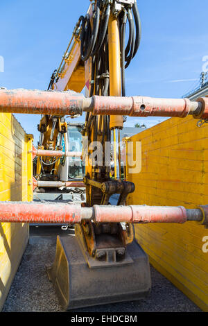 Escavatore parcheggiato su un sito in costruzione. Foto Stock