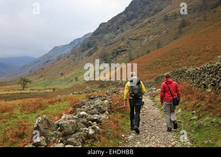 Due uomini a piedi su un percorso attraverso la valle Langstrath nel Parco Nazionale del Distretto dei Laghi. Borrowdale Cumbria Inghilterra UK Gran Bretagna Foto Stock