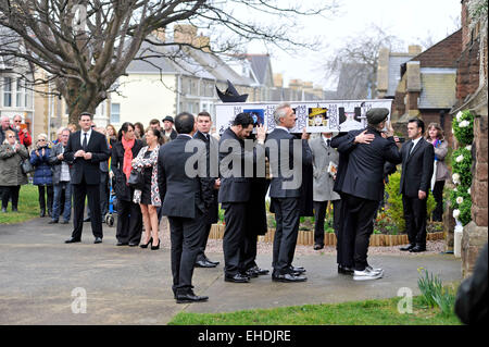 Porthcawl, Wales, Regno Unito. Xii Mar, 2015. Funerali di Steve strano, Chiesa di Tutti i Santi di Porthcawl, Wales, Regno Unito. Martin Kemp di Spandau Ballet e Boy George portano la bara nella chiesa come Tony Hadley guarda (sinistra). Credito: Phil Rees/Alamy Live News Foto Stock