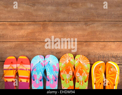 Vivacemente colorato flip-flop su legno Foto Stock