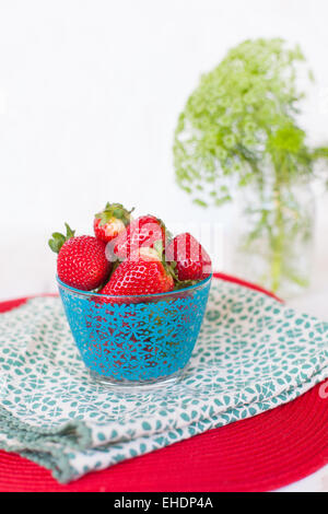 Elegante tazza di fragole fresche con fiori Foto Stock