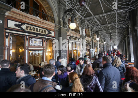 Un grande gruppo di persone a piedi nella parte anteriore del caffè Florian in Procuratie Nuove in Piazza San Marco a Venezia, Italia. Foto Stock