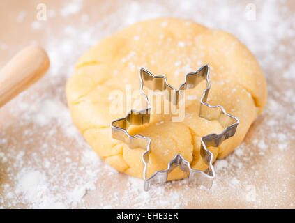 Pasta frolla pasta con cookie cutter su una superficie infarinata, il fuoco selettivo Foto Stock