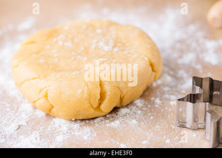 Pasta frolla pasta, srotolato e crudi su una superficie infarinata, closeup, il fuoco selettivo Foto Stock