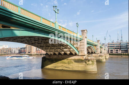 Southwark Bridge, una strada ponte che attraversa il fiume Tamigi, Londra visto dalla banca del sud in una bella e soleggiata giornata con cielo blu e soffici nuvole bianche Foto Stock