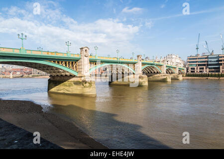 Southwark Bridge, una strada ponte che attraversa il fiume Tamigi, Londra visto dalla banca del sud in una bella e soleggiata giornata con cielo blu e soffici nuvole bianche Foto Stock