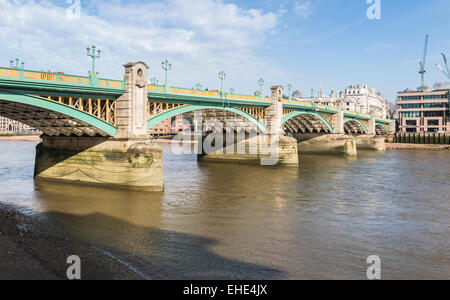 Southwark Bridge, una strada ponte che attraversa il fiume Tamigi, Londra visto dalla banca del sud in una bella e soleggiata giornata con cielo blu e soffici nuvole bianche Foto Stock