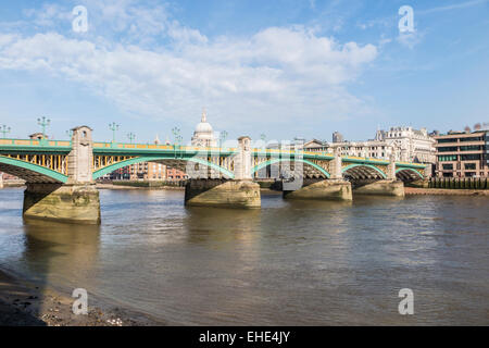 Southwark Bridge, una strada ponte che attraversa il fiume Tamigi, Londra visto dalla banca del sud in una bella e soleggiata giornata con cielo blu e soffici nuvole bianche Foto Stock