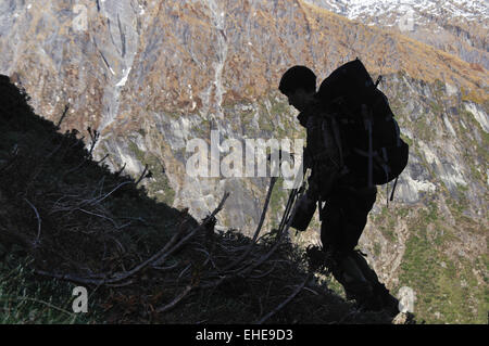 Un cacciatore bilancia le pendici delle Alpi del Sud della Nuova Zelanda mentre cerca di selvaggina Foto Stock