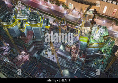 Sito in costruzione di appartamento torri grattacielo sotto i proiettori di notte in Dubai Emirati Arabi Uniti Foto Stock