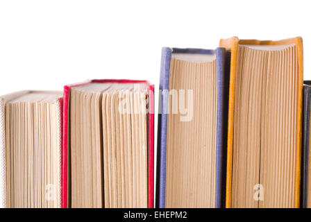 Vecchi libri in una riga su sfondo bianco. Foto Stock