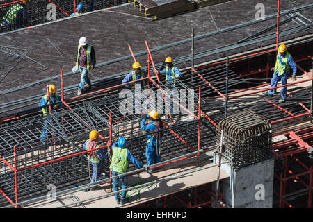 I lavoratori migranti sul sito di costruzione di alto grattacielo appartamento Tower a Dubai Emirati Arabi Uniti Foto Stock