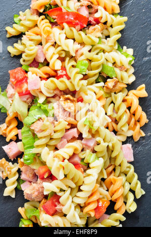 Primo piano di una rinfrescante insalata di pasta su un sfondo di ardesia Foto Stock