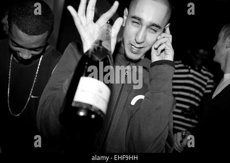 Ragazzo con bottiglia di champagne sul suo telefono cellulare presso la bomba al Ministero del suono 8 Ott 2009. Foto Stock